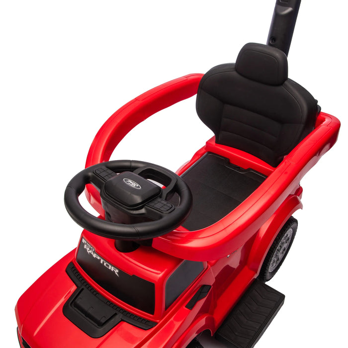 Red Raptor ride-on toy car for kids with black seat, steering wheel, and safety bar, close-up view.
