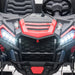 Kids ride-on car close-up showing red and black front grille, headlights, and steering wheel.