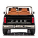 Ford F-150 kids ride-on toy car shown from the rear with brown seats and realistic detailing.