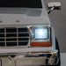 White toy car front with chrome grille and headlight illuminated, close-up view.