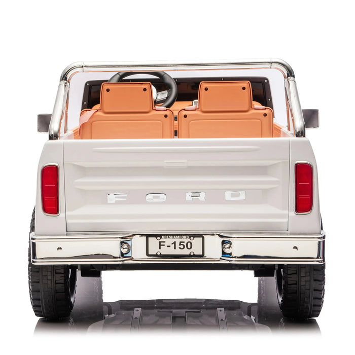 Kids Ford F-150 ride-on truck in white, shown from the rear with two tan seats and chrome accents.