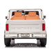 Kids Ford F-150 ride-on truck in white, shown from the rear with two tan seats and chrome accents.