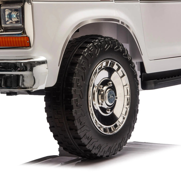 Ford truck toy model front wheel close-up showing detailed tire and chrome hubcap on white background.