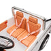 Kids ride-on car tan seats with seat belts, shown from above inside a white toy vehicle.