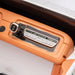 Toy car dashboard close-up with control buttons and USB port on orange panel.