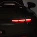Children’s ride-on car tail light illuminated in a dark indoor setting.