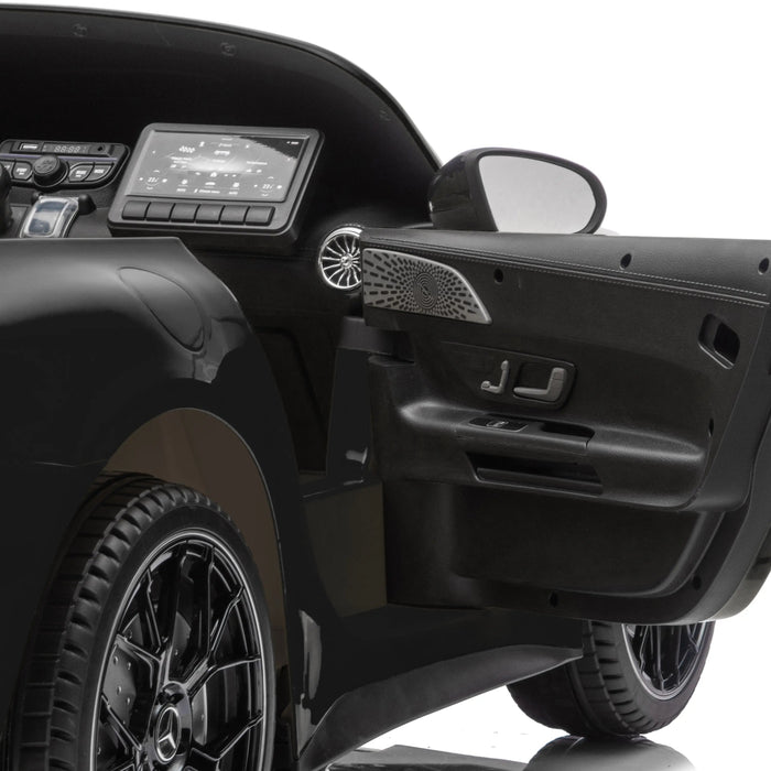 Kids ride-on car black interior detail with open door and dashboard in close-up view.