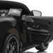 Kids ride-on car black interior detail with open door and dashboard in close-up view.