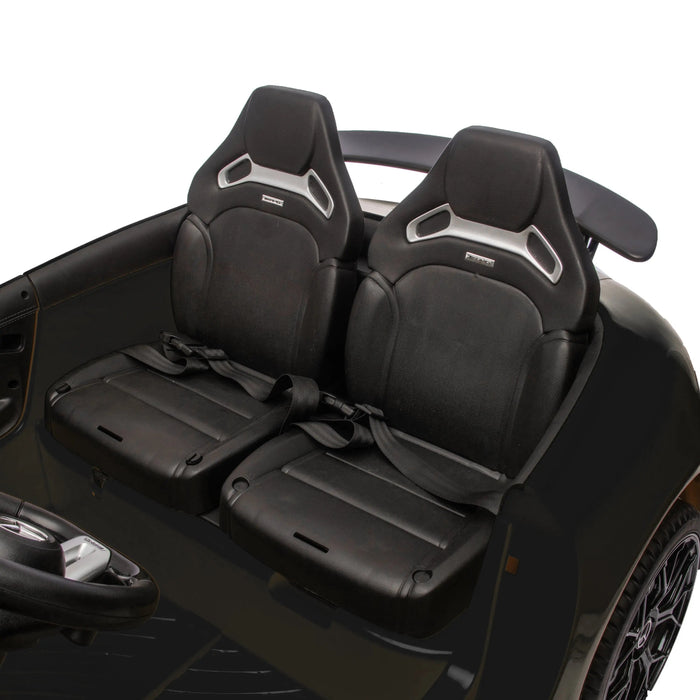 Kids electric ride-on car interior with two black seats and seatbelts, close-up view.