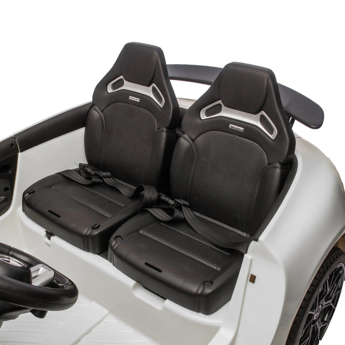 Children’s ride-on car with two black seats and safety belts shown in a close-up interior view.