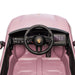 Porsche kids ride-on car dashboard close-up showing steering wheel and control panel in pink.