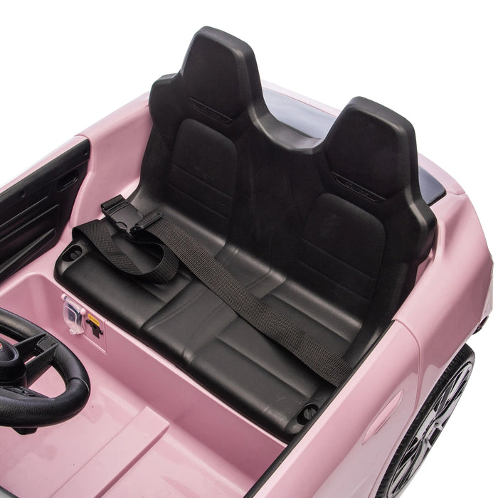 Pink kids ride-on car with two black seats and seatbelt, viewed from above.