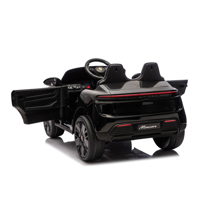 Kids electric ride-on Porsche Macan car in black shown from the rear with doors open on white background.