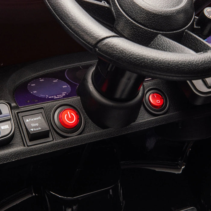 Kids ride-on car dashboard closeup showing steering wheel, control buttons, and power switch.