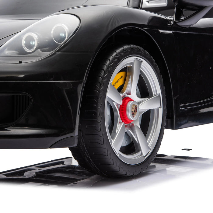 Ride-on Porsche car close-up showing detailed front headlight and wheel on a white background.