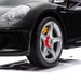 Ride-on Porsche car close-up showing detailed front headlight and wheel on a white background.