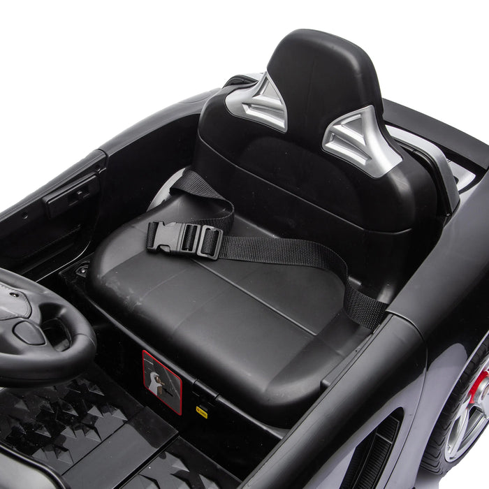 Kids ride-on car seat with seatbelt shown in a close-up, black plastic interior and steering wheel visible.