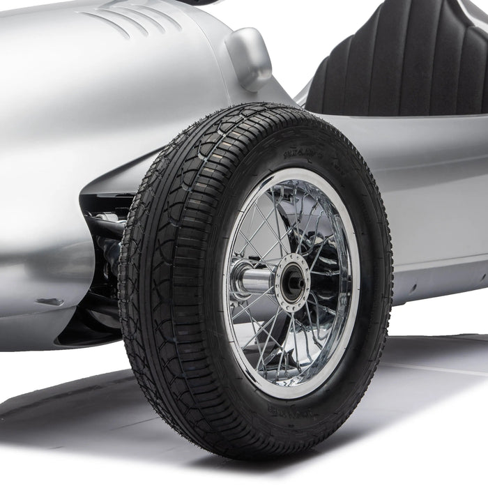 Children’s silver ride-on car close-up showing detailed front wheel and side body design.