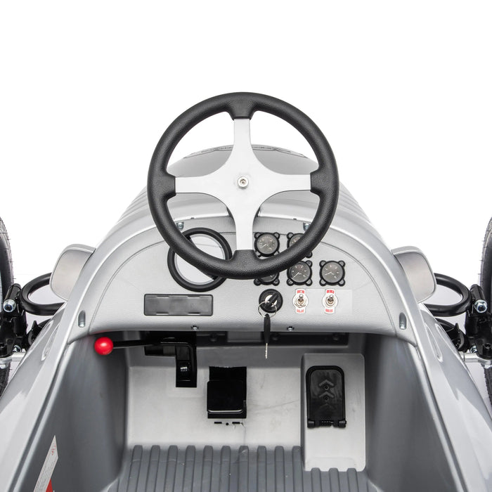 Children's ride-on toy car dashboard showing steering wheel, pedals, and control panel.