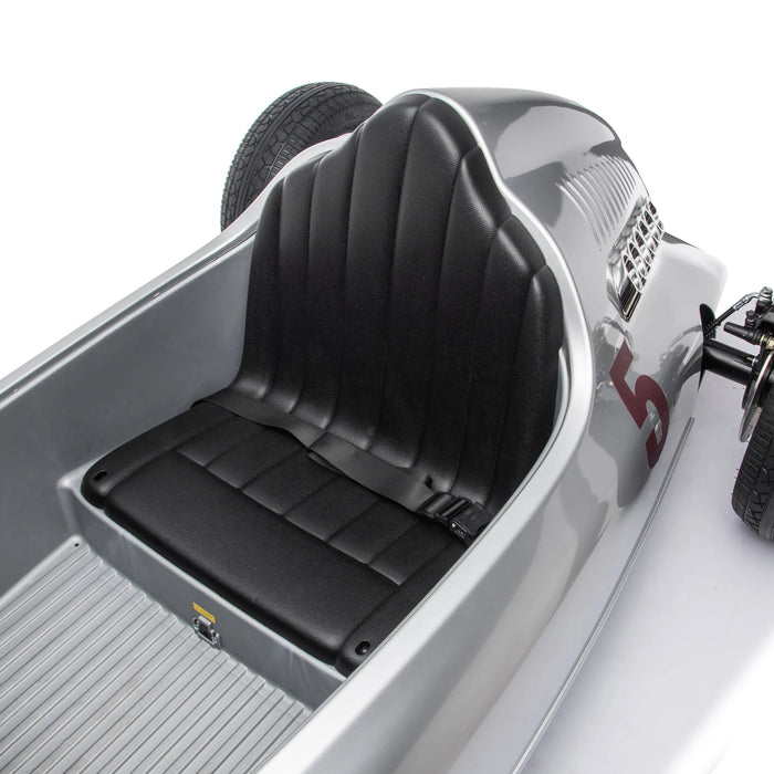Children’s ride-on race car seat detail in silver with safety belt and number 5 on side.