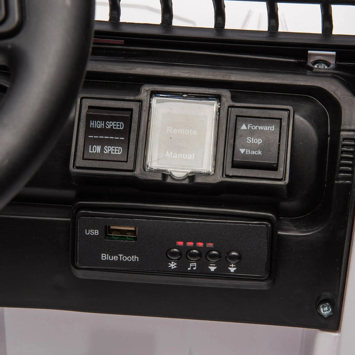 Kids ride-on car dashboard with speed controls, remote manual switch, and Bluetooth USB panel visible.
