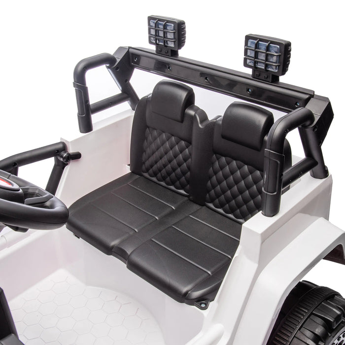 Kids ride-on car with two black quilted seats and steering wheel shown in close-up view.