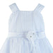 Flower girl dress white with ribbon waist and floral embellishment, shown on a plain background.