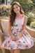 Pink roses and butterflies silky dress for girls, shown outdoors on a wicker chair.