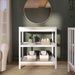 White baby changing table with shelves, storage baskets, and nursery decor in a modern room