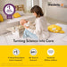 Medela breast pump ad showing a mother holding her baby in a bright, cozy living room setting.