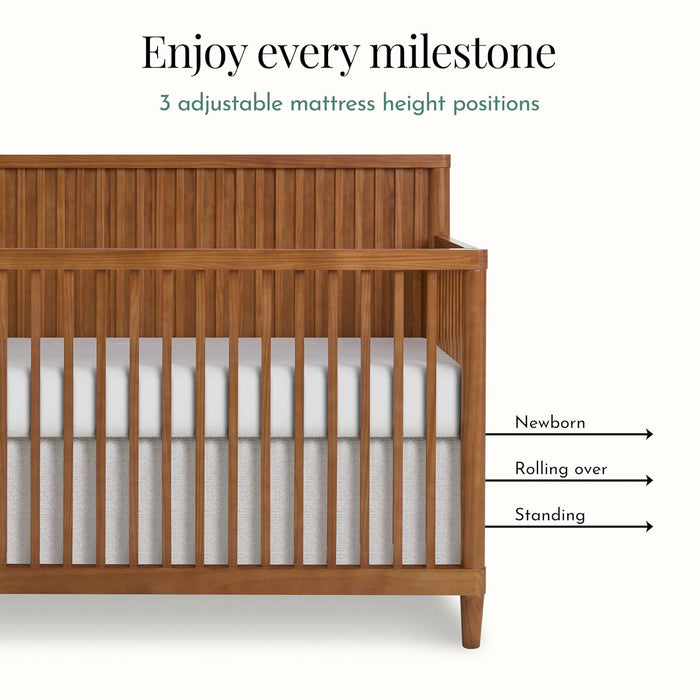 Wooden baby crib with three adjustable mattress height positions for newborn, rolling over, and standing stages.