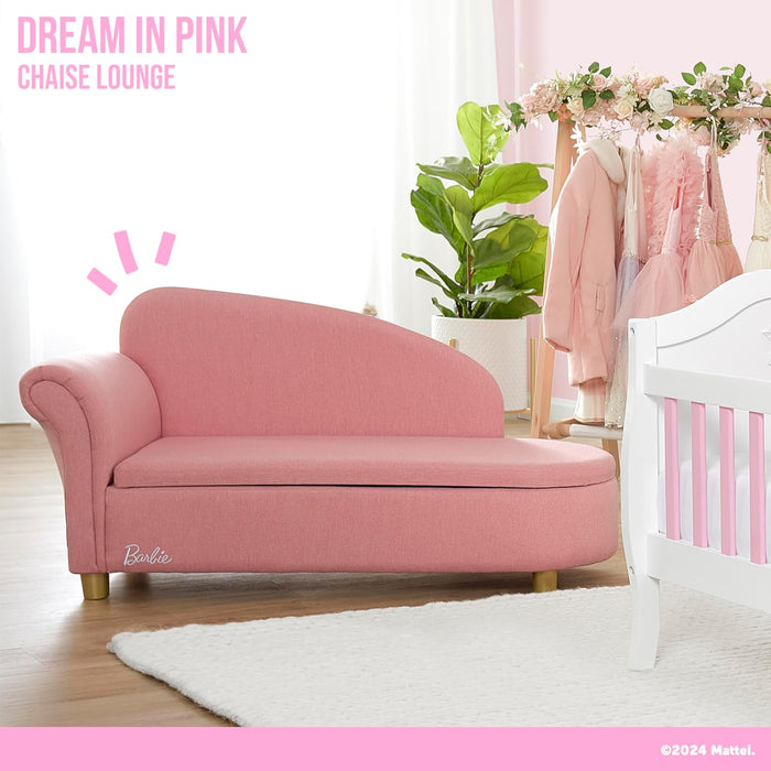 Pink chaise lounge for kids in a nursery room with dresses, crib, and plant