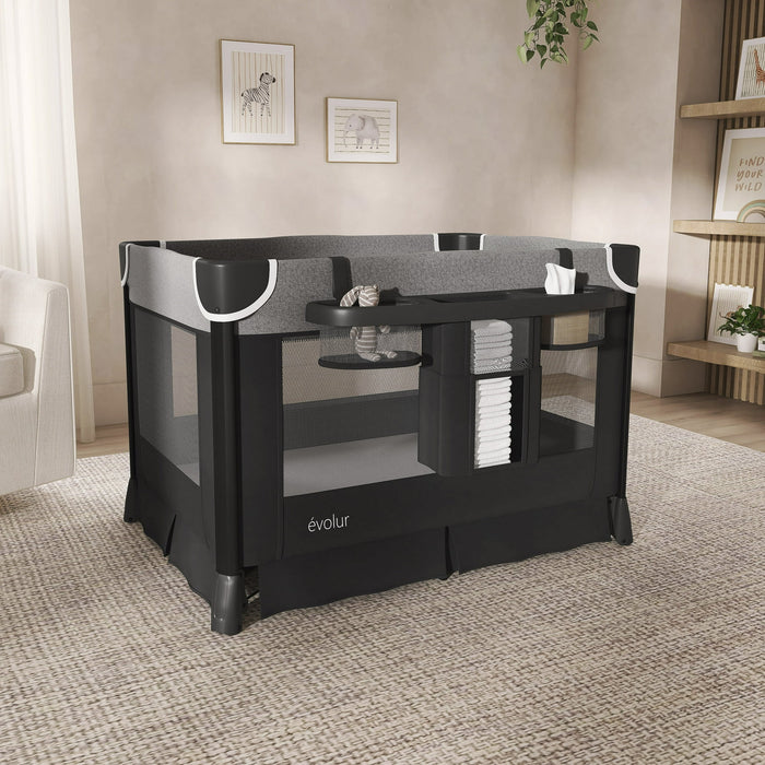 Black and grey baby playpen with mesh sides and changing station in a modern nursery room