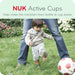 NUK Active Cups shown in an outdoor setting with a toddler kicking a soccer ball on grass.