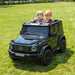 Mercedes G63 ride-on toy car with two children sitting inside, shown outdoors on grass.
