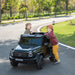 Kids electric ride-on Mercedes G63 car with two children playing outdoors on a sunny day.