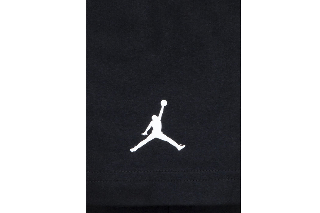 Black kids' t-shirt featuring white basketball player silhouette logo on the front close-up.