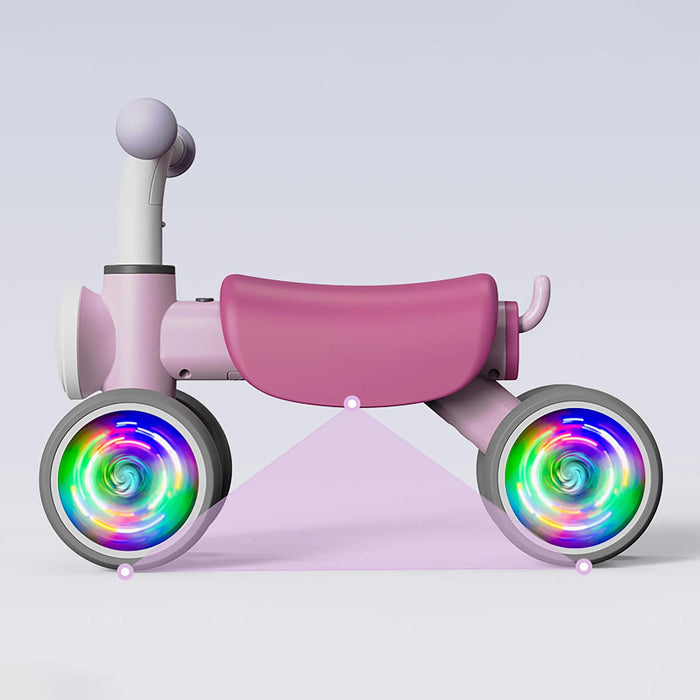 Pink toddler balance bike with LED light-up wheels against a plain light background.
