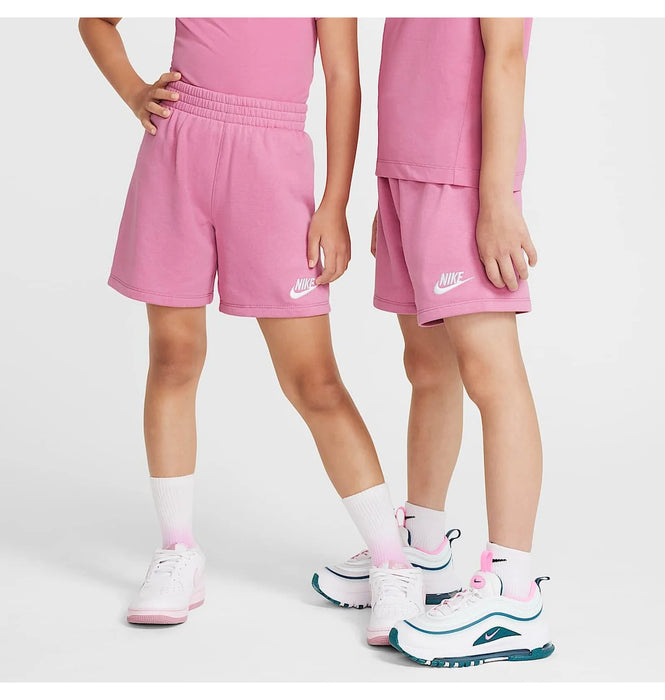 Nike kids’ pink shorts and t-shirts modeled by two children standing on a white background.