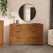Modern wooden dresser with six drawers, round mirror, lamp, nursery decor, and neutral tones