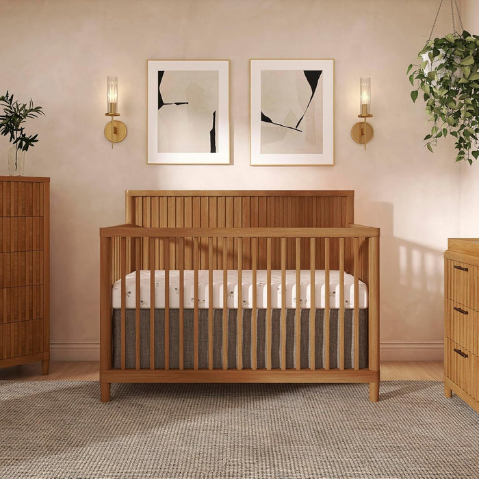 Modern wooden baby crib in nursery with mattress, wall art and plants