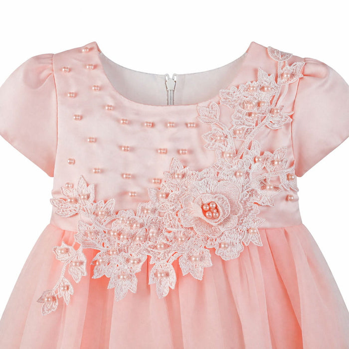Peach baby dress with floral lace applique and pearl accents shown on white background.
