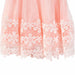 Peach dress with floral lace hem shown in close-up, highlighting delicate embroidery details.