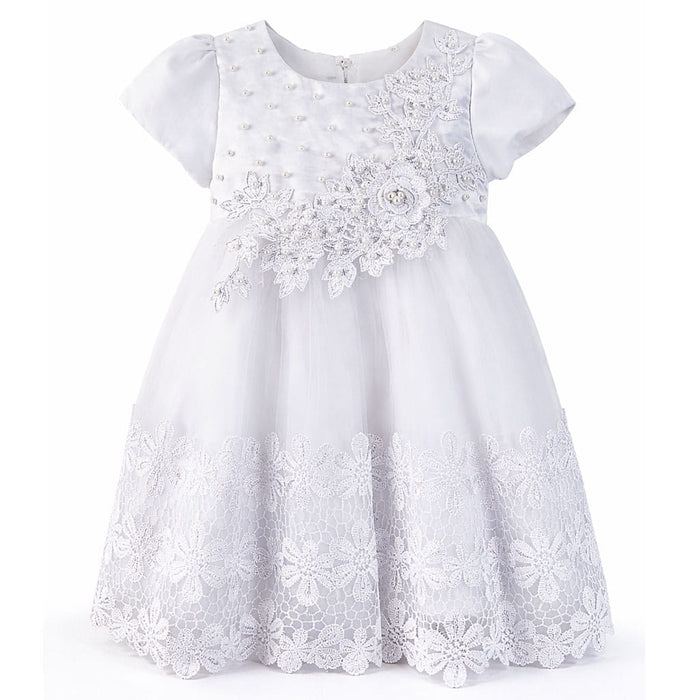 White baby dress with lace and floral embroidery displayed against a plain background.