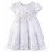 White baby dress with lace and floral embroidery displayed against a plain background.