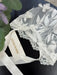 Teter Warm baby lace bonnet with 3D leaf details and ribbon ties displayed on a dark surface.