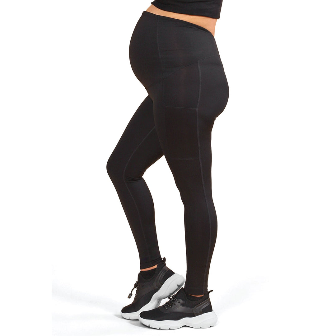 ATHENA black maternity leggings shown on a pregnant person standing in profile.