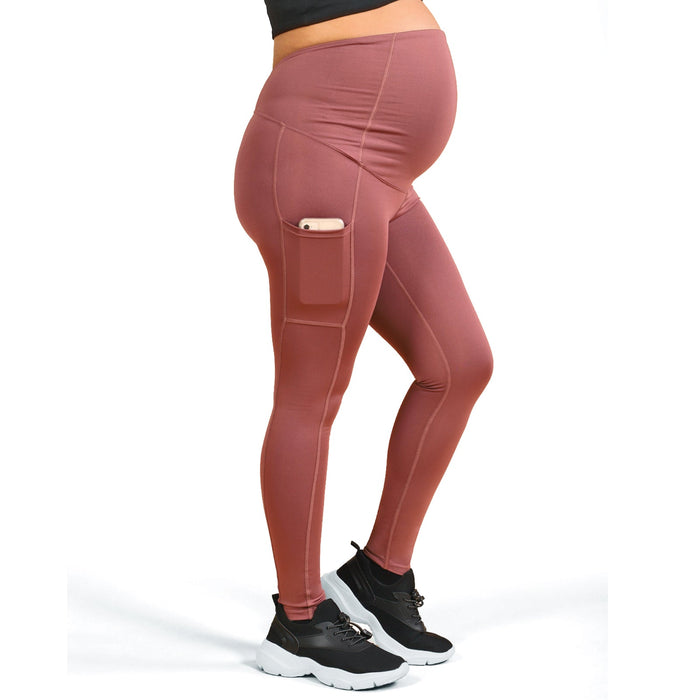 ATHENA RB CELL maternity leggings in rose, shown on pregnant model with side pocket holding a phone.