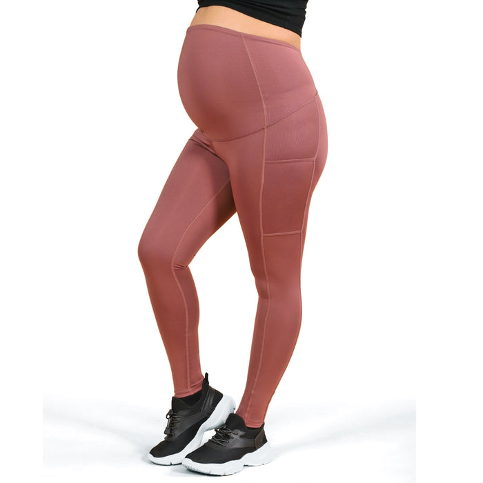 ATHENA maternity leggings in rose color shown on a pregnant woman standing, side view.