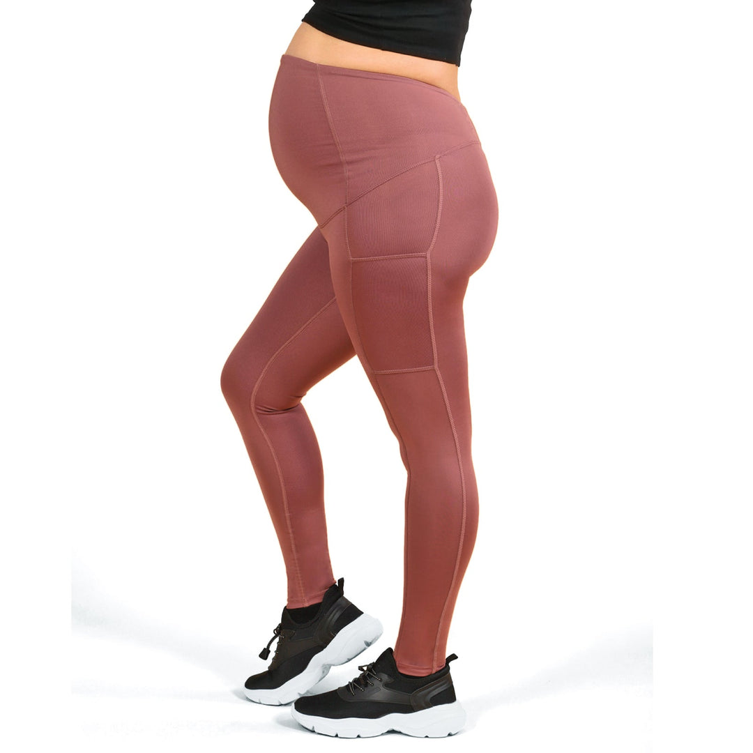 ATHENA maternity leggings in rose brown worn by a pregnant person standing on a white background.